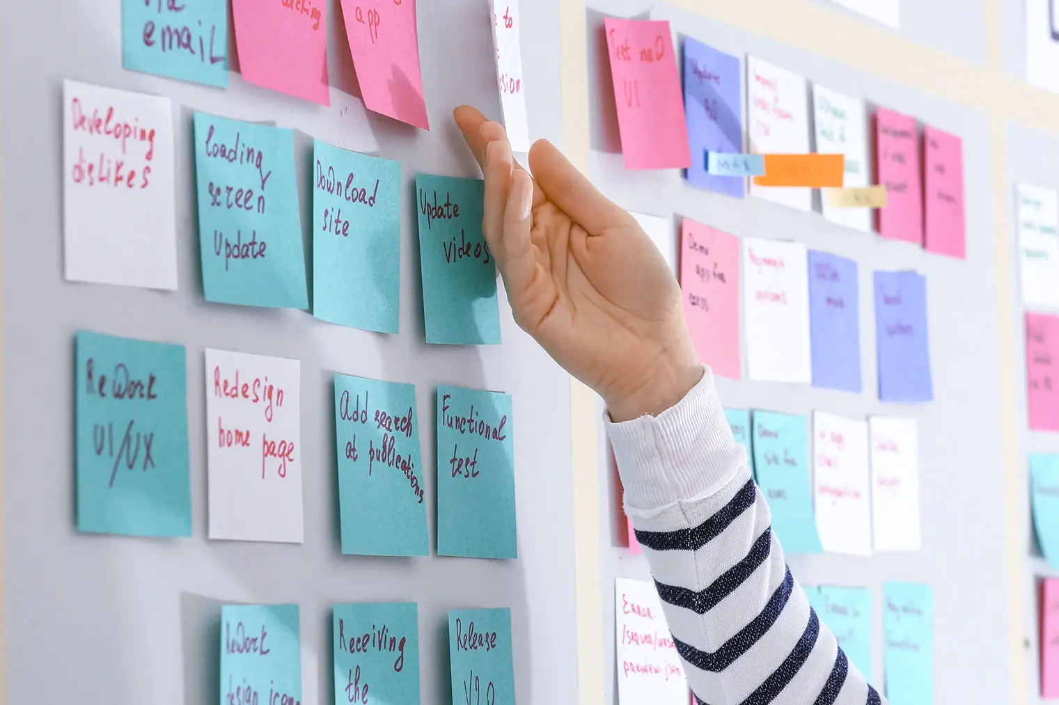 Scrum master planning team process with sticky notes on the board wall