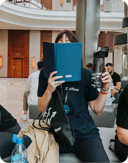 Ziflow member reading a notebook with a bottle in a hand