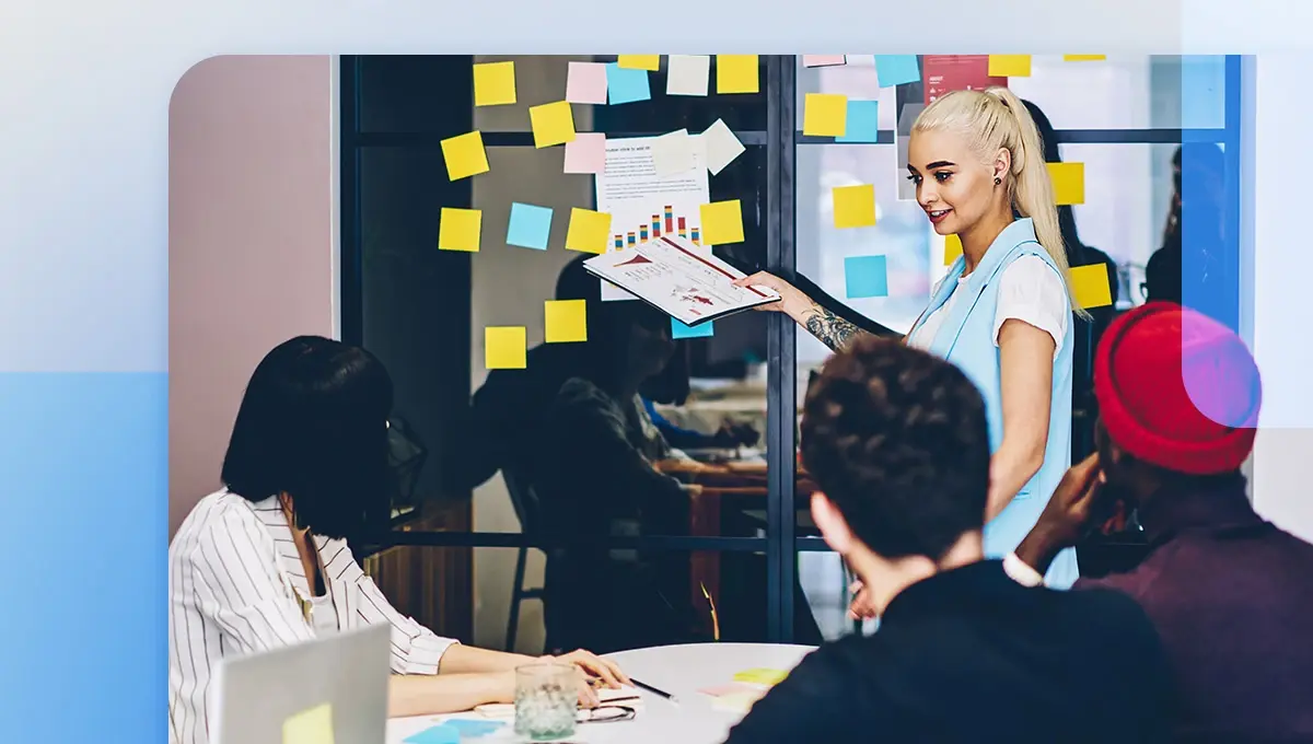 Creative operations manager talking with a design team in front of sticky note wall